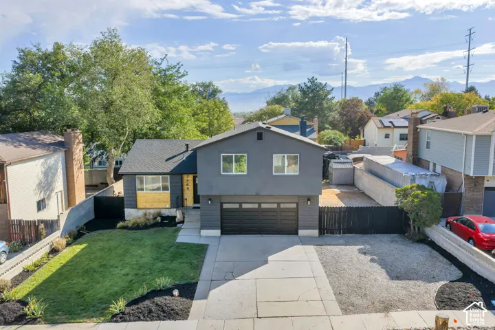Modernized exterior with a dark facade, contrasting wood-look accents, and a black garage door