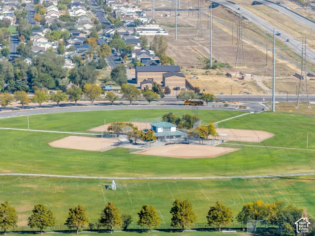 Expansive green space featuring multiple baseball diamonds, a multi-use field, and a concession stand building