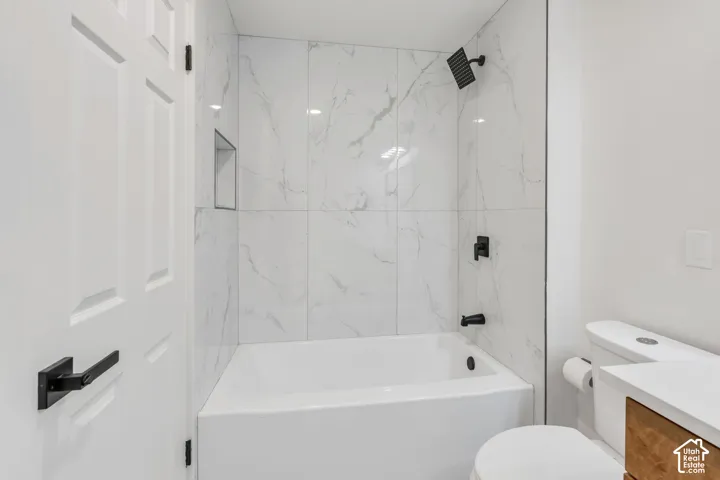 White subway tile shower surround with black fixtures and built-in niche