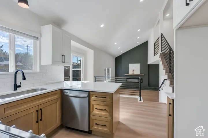 Kitchen featuring wood-finish lower cabinetry, white upper cabinetry, and white countertops