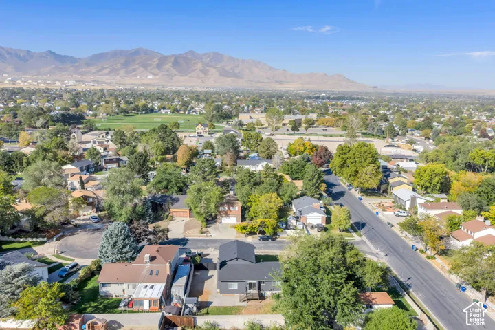 Expansive residential neighborhood with mature trees, green spaces, and a mountain backdrop