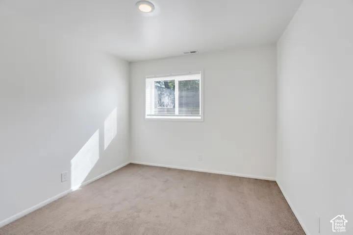 Neutral wall paint, recessed ceiling light, window with blinds, and carpeted flooring