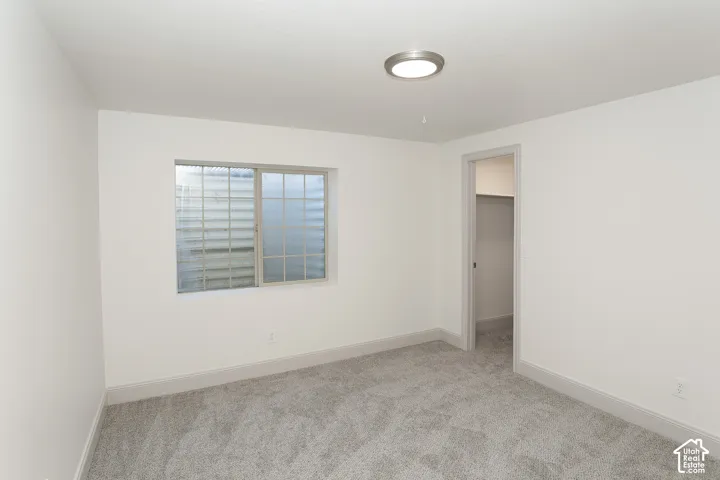 Neutral wall paint, gray carpet flooring, recessed window, and flush-mount ceiling light
