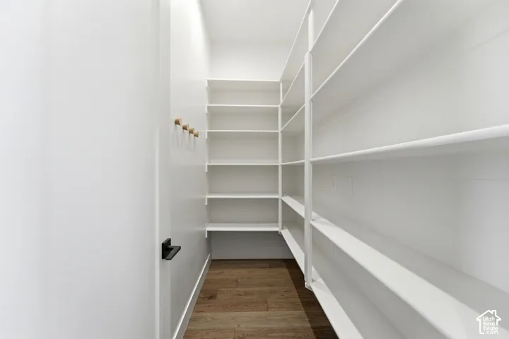 Integrated wall-to-wall shelving, wood-finish flooring, recessed lighting, and wall-mounted hooks