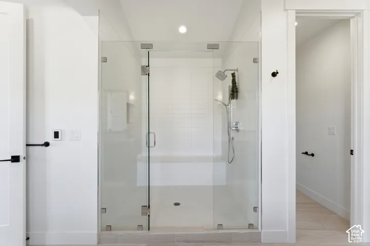 Glass-enclosed shower with subway tile surround, built-in bench, and a rainfall showerhead