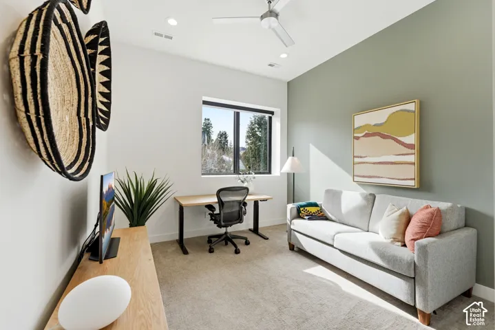 Versatile home office featuring a wood-finish desk, ergonomic task seating, and abundant natural light from a large window