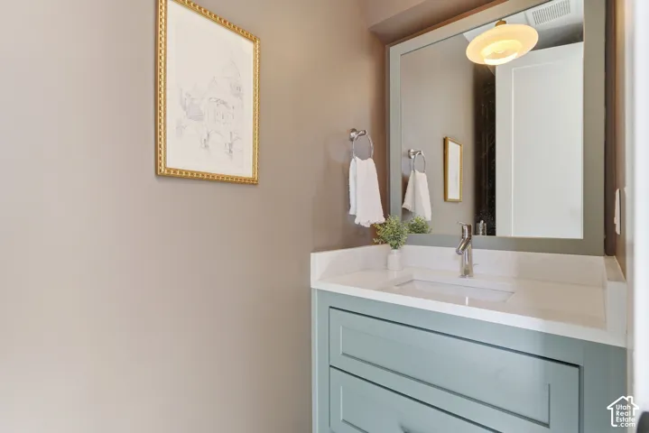 Light blue vanity with a white countertop and an integrated rectangular sink