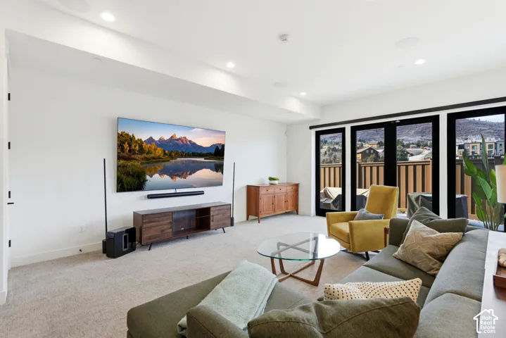 Recessed lighting, light-toned carpeting, and a full-height glass door with transom
