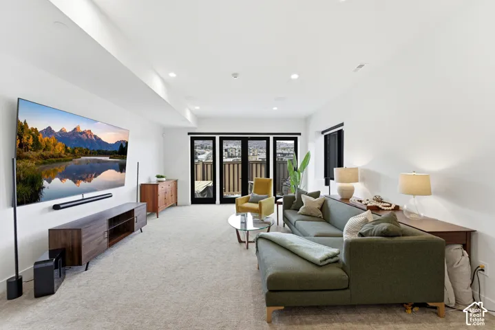 Sophisticated entertainment space featuring recessed ceiling lighting, wide-plank wood-finish flooring, and a custom media wall with integrated cabinetry