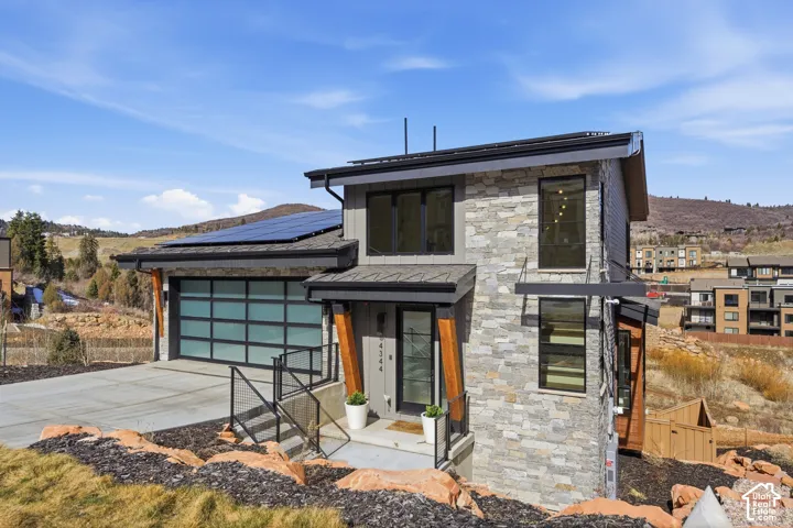 Modern residential home featuring a sleek stone and metal exterior with clean geometric lines