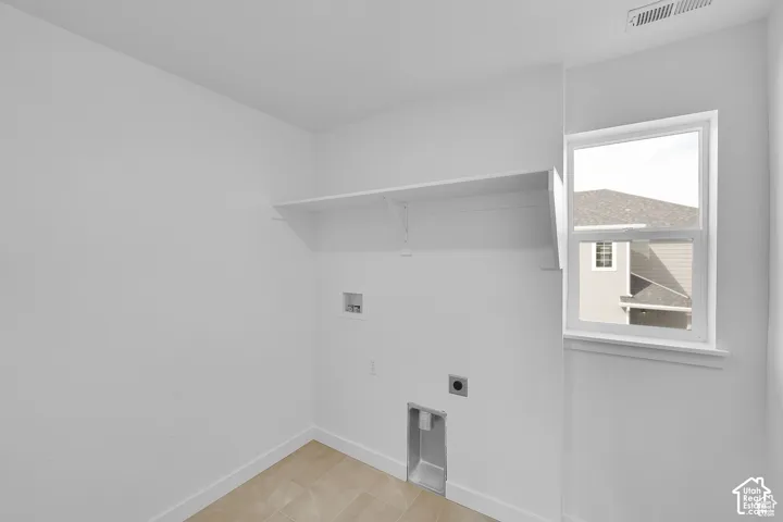 Laundry area featuring a single window, a wall-mounted shelf, and tile flooring