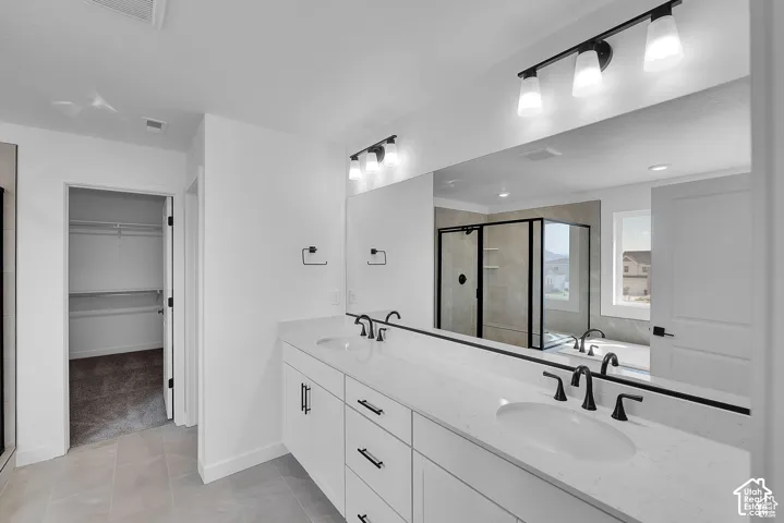 Dual vanity with white cabinetry, stone-finish countertop, and matte black fixtures