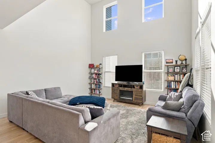 Vaulted ceiling, multiple windows, wood-finish flooring, built-in shelving, media console with integrated electric fireplace