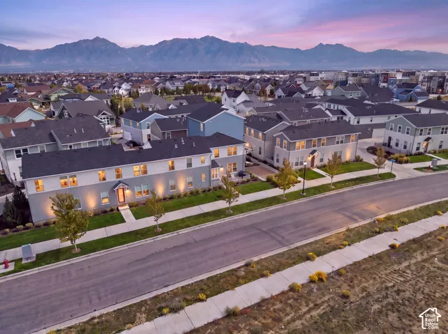 Modern residential architecture with a neutral color palette, featuring a well-maintained street and manicured landscaping