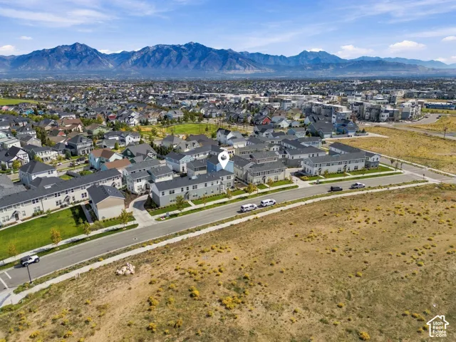 Mountain backdrop, residential area, paved road, pedestrian sidewalk, undeveloped land