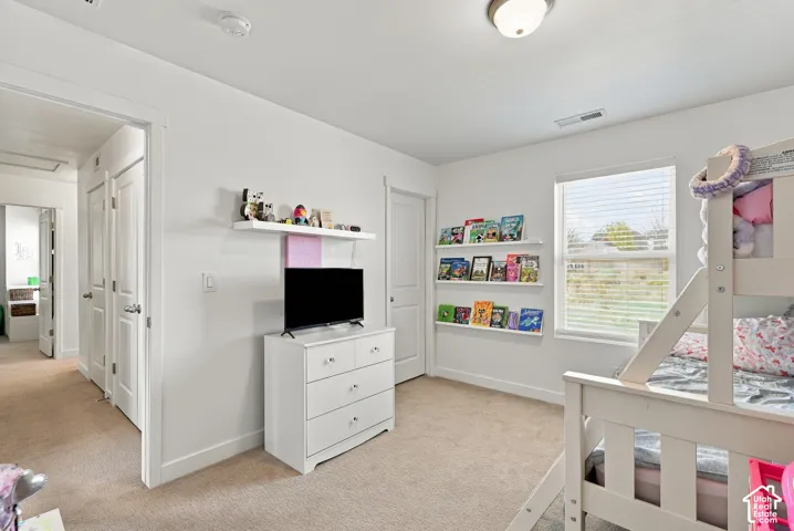 Neutral wall color with recessed lighting, carpet flooring, and a single window with blinds