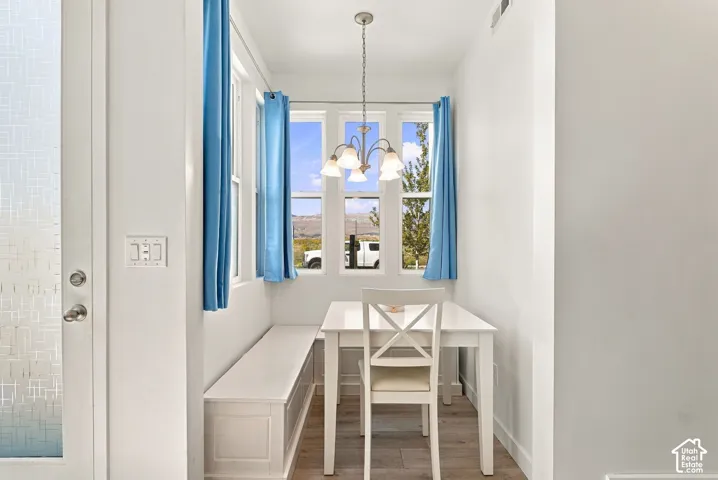 Built-in dining bench, multiple windows, and a hanging chandelier with four lights