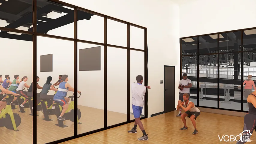 Spacious fitness area featuring wood-finish flooring, high ceilings, and expansive glass partitions