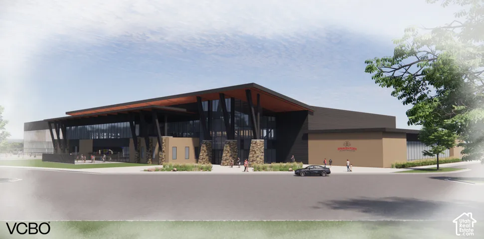 Modern commercial building with expansive glass facades, stone accents, a deep overhang, and a paved entrance