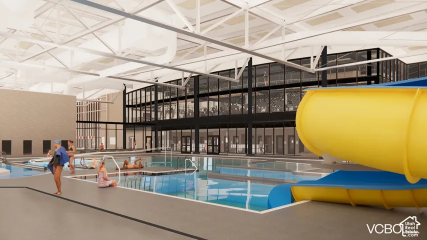 Indoor pool facility featuring a water slide, multiple pool areas, and a spacious deck