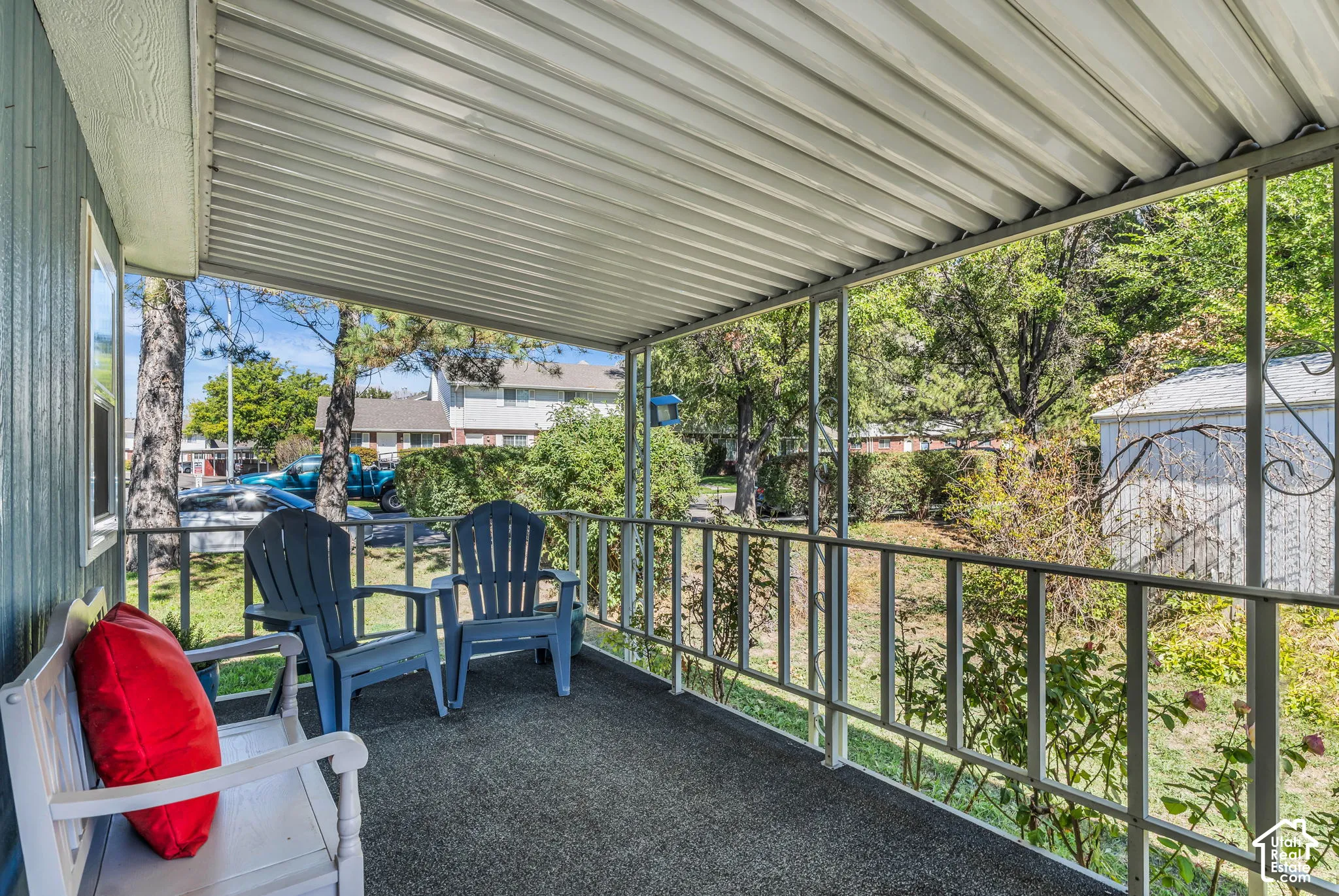 Covered porch with metal railing and textured flooring