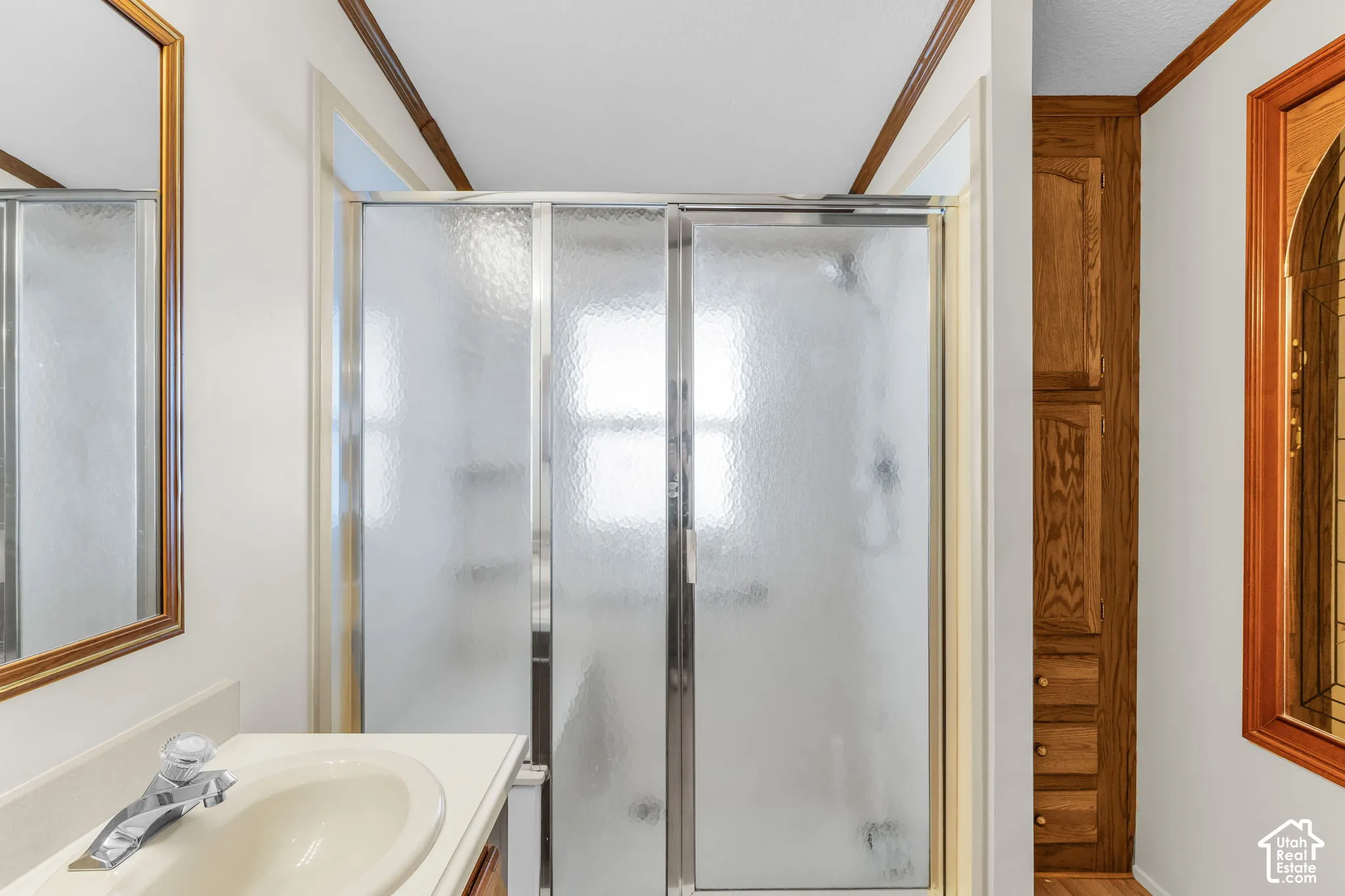 Vanity with integrated sink, polished chrome faucet, and framed mirror
