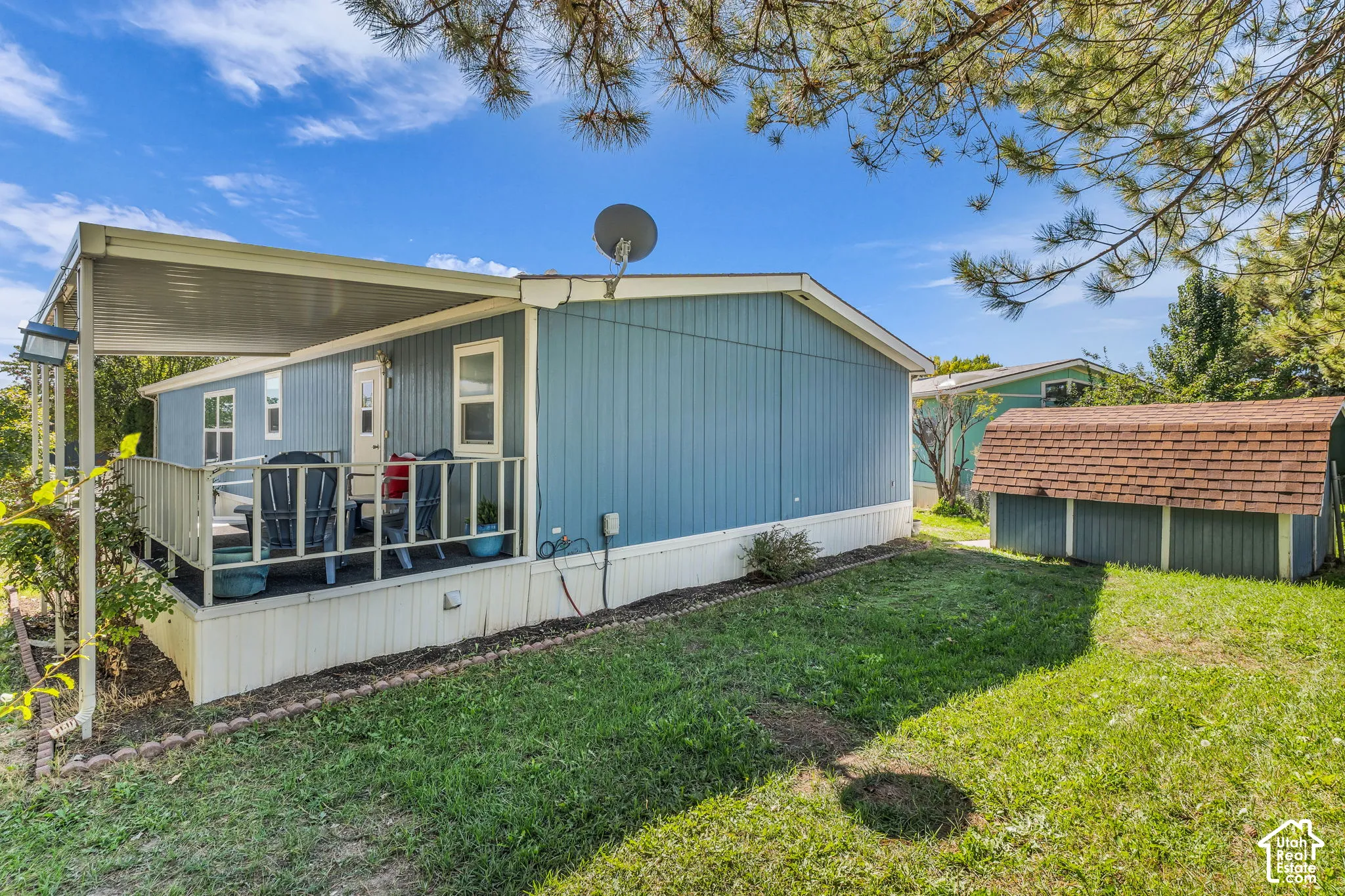 Covered patio with railing, exterior siding, and a detached storage shed