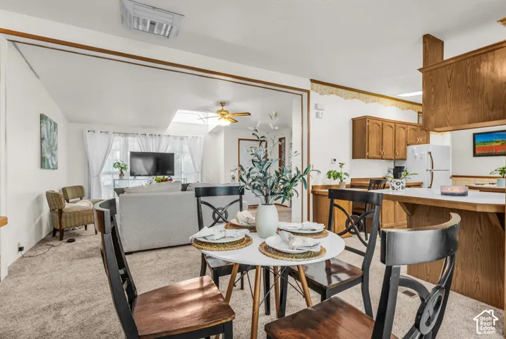 Open-concept living space featuring wood-finish cabinetry, white countertops, and a skylight