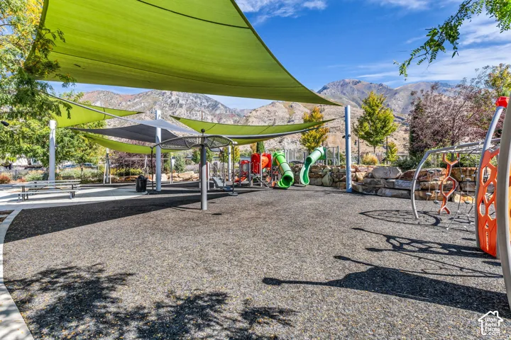 Community playground featuring shade structures, play equipment, and a soft-surface ground cover