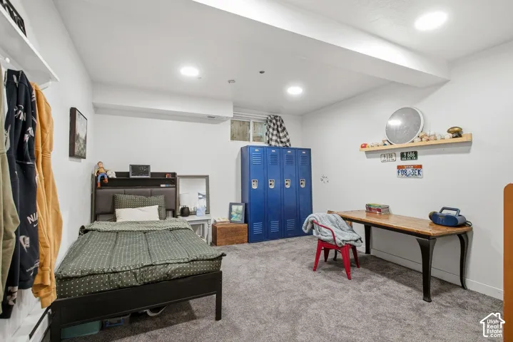 Recessed lighting illuminates the space, featuring white walls and a carpeted floor