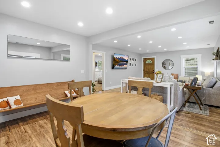 Open-concept living space with recessed lighting, wood-finish flooring, and light-colored walls
