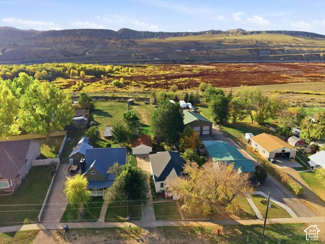 Multiple residential structures, including houses with blue and brown roofs, and several detached garages with green and tan roofs