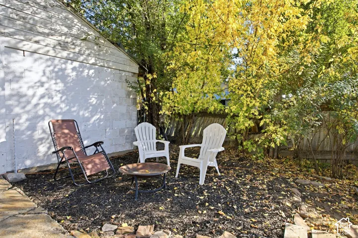 Backyard featuring mature trees, a wooden privacy fence, and a concrete patio
