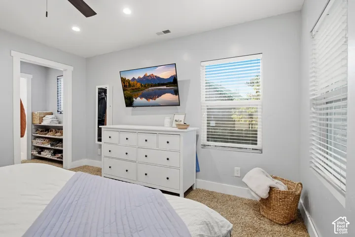 Recessed lighting, ceiling fan, carpet flooring, and two windows with blinds