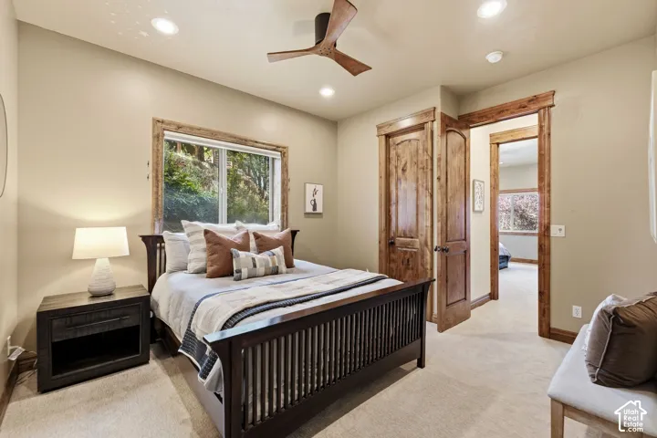 Wood-finish ceiling fan, recessed lighting, and a window with natural wood trim