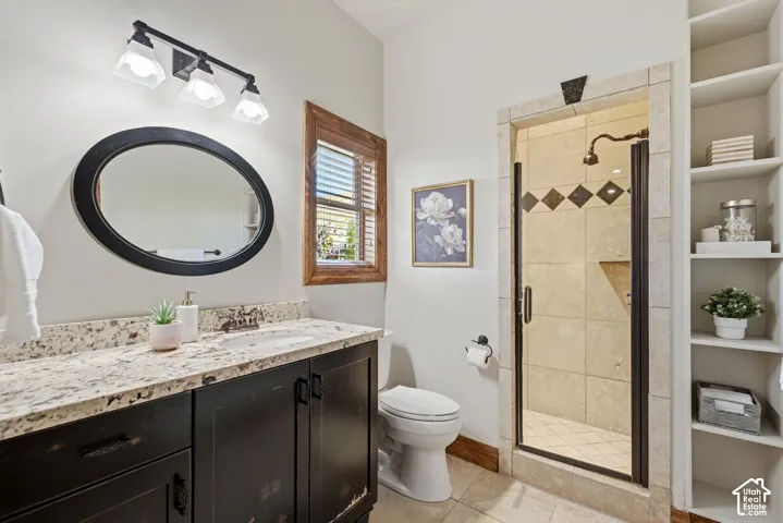 Granite-style countertop with an undermount sink, dark wood-finish vanity, and a framed oval mirror