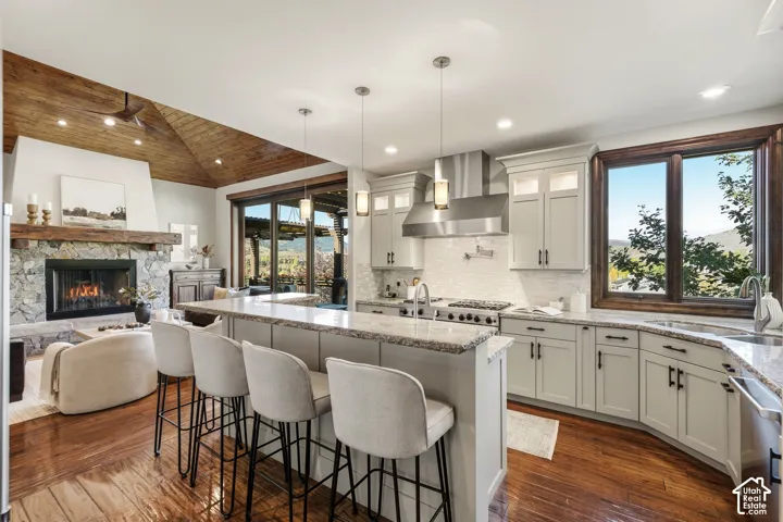 Gourmet kitchen with light-toned cabinetry, stainless steel range hood, and granite countertops