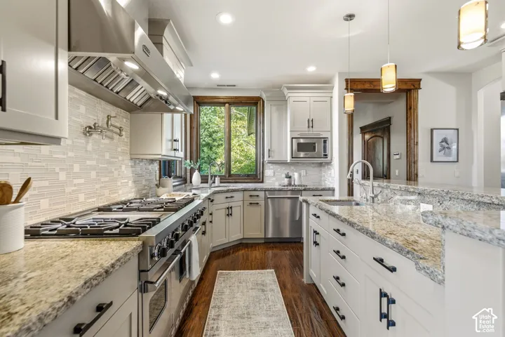 Gourmet kitchen featuring a professional-grade range, stainless steel appliances, granite countertops, an undermount sink, and recessed lighting