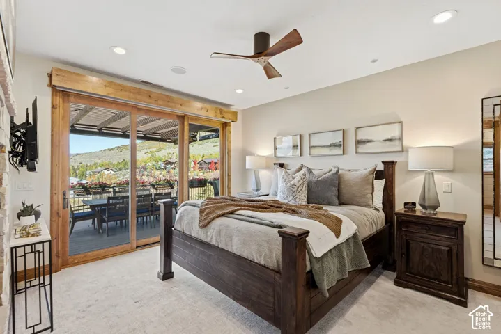 Expansive sliding glass doors, recessed lighting, ceiling fan, and direct access to an outdoor deck