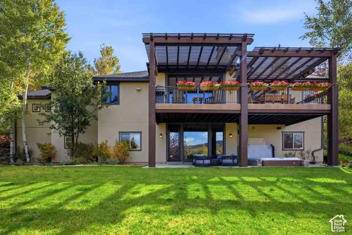 Stucco exterior with multi-level covered decks featuring pergolas