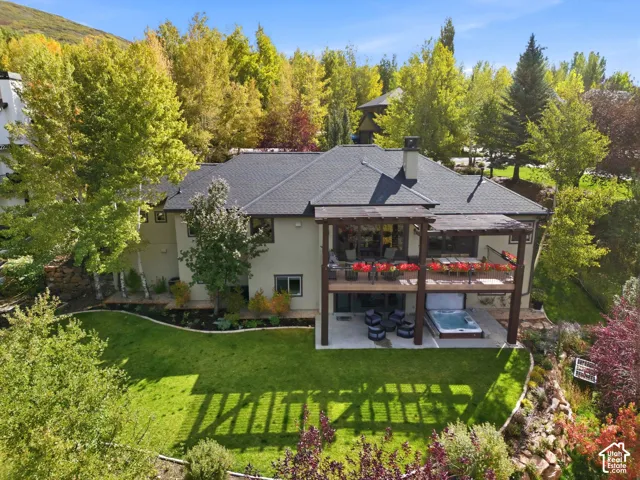 Multi-level property featuring a dark shingle roof, dual-level outdoor decks with wood pergolas, and an integrated hot tub