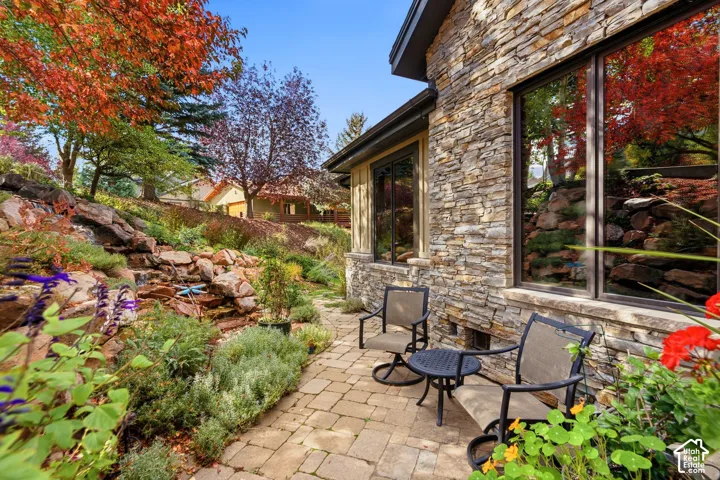Stone veneer exterior with large windows and a paver patio