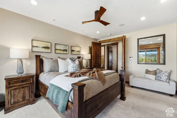 Recessed lighting, ceiling fan with wood-finish blades, and neutral-toned wall paint