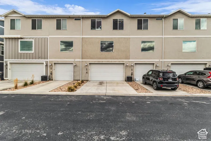 Multi-level townhome exterior featuring stucco and vertical siding