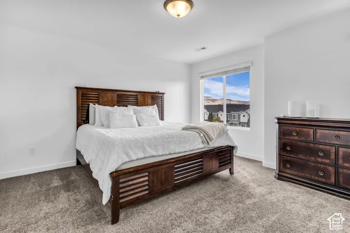 Expansive room with neutral carpeting, large window, and recessed lighting