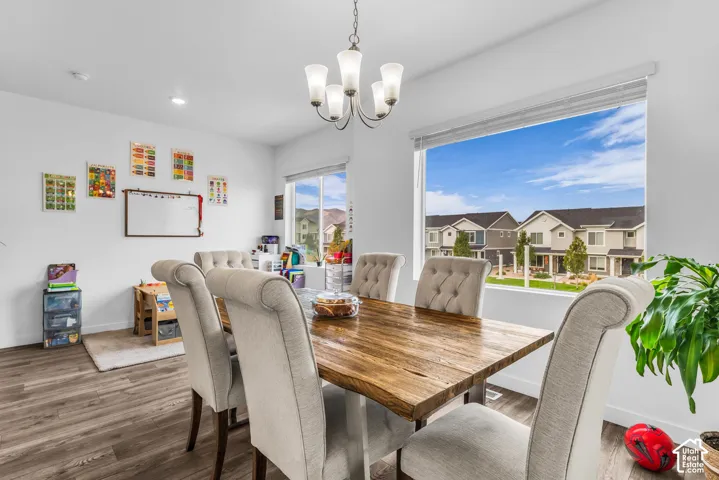 Wood-finish flooring, recessed lighting, and a contemporary chandelier