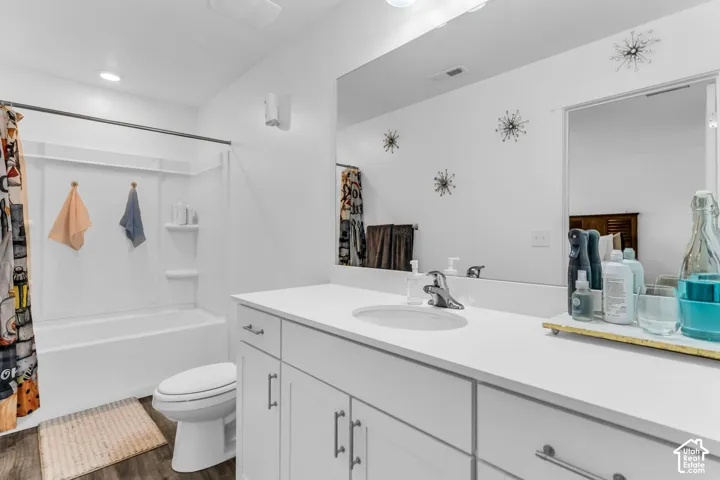 Bathroom featuring a white vanity with integrated sink, white countertop, and dark-finish cabinet hardware