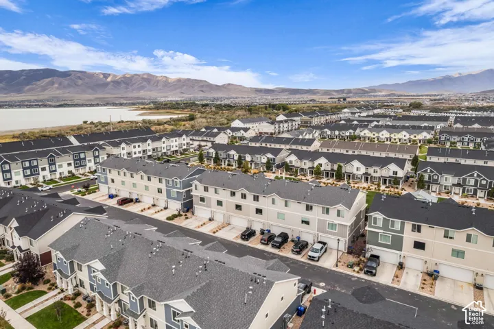 Modern townhome community with varied exterior finishes, attached garages, and a mountainous backdrop