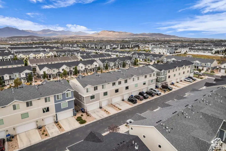 Newly constructed townhome community with attached garages, paved driveways, and mountain scenery