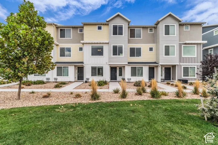 Contemporary townhome exterior with mixed siding, multiple windows, and individual entrances